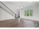 Bright, open living area with hardwood floors, staircase, large windows, and modern light fixture at 6712 Cove Ln, Sherrills Ford, NC 28673