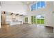 Open-concept space with hardwood floors, living area, kitchen, and large windows and sliders at 6712 Cove Ln, Sherrills Ford, NC 28673
