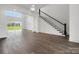 Open-concept living room featuring hardwood floors, large windows, and a modern staircase at 6712 Cove Ln, Sherrills Ford, NC 28673