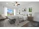 Airy bedroom featuring a ceiling fan, neutral-toned bedding, and large windows at 6712 Cove Ln, Sherrills Ford, NC 28673