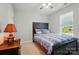 Simple bedroom with a dark wood bed frame and dresser, window view, and a ceiling fan at 8004 Fountainbrook Dr # 15, Indian Trail, NC 28079