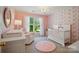 Sweet Bedroom featuring pink walls, floral wallpaper, white crib, and a fluffy rug at 8004 Fountainbrook Dr # 15, Indian Trail, NC 28079