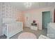 Charming Bedroom with crib, pink accents, and floral wallpaper at 8004 Fountainbrook Dr # 15, Indian Trail, NC 28079