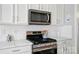 Close-up of kitchen showcasing white cabinets, stainless steel appliances, and modern finishes at 8004 Fountainbrook Dr # 15, Indian Trail, NC 28079