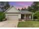 Charming single-story home with a garage and inviting front porch with craftsman-style details and manicured landscaping at 8112 Mossy Rock Rd, Waxhaw, NC 28173