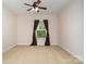 Cozy bedroom with large window, neutral walls, carpet flooring and a ceiling fan at 9802 Sky Vista Dr, Huntersville, NC 28078