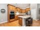 Bright kitchen featuring wood cabinets, stainless steel appliances, and an island with bar seating at 9802 Sky Vista Dr, Huntersville, NC 28078