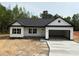 Charming single-story home featuring a modern black and white exterior, attached garage, and a well-manicured lawn at Lot 9 Lilly Pad Dr, Salisbury, NC 28146