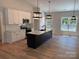 Bright kitchen with white cabinets, stainless steel appliances, large island and stylish pendant lighting at Lot 9 Lilly Pad Dr, Salisbury, NC 28146