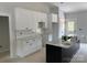 Bright kitchen featuring white cabinetry, a gray tiled backsplash, marble countertops, and a dark island at Lot 9 Lilly Pad Dr, Salisbury, NC 28146