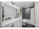 Bathroom with modern vanity, dual sinks, sleek tile, and a shower-tub combination at 10009 Lattice Ct, Charlotte, NC 28269