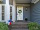 Inviting front porch with a wreath-adorned door, potted plants, and brick steps at 10009 Lattice Ct, Charlotte, NC 28269