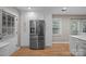 Bright kitchen featuring stainless steel refrigerator, white cabinets, and hardwood flooring at 10009 Lattice Ct, Charlotte, NC 28269