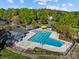 Aerial view of a community pool with an adjacent pool house, fenced perimeter, and lounging area at 10009 Lattice Ct, Charlotte, NC 28269
