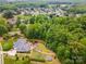 Aerial view of the house showcasing its location in a lush, wooded neighborhood with mature trees and landscaping at 10012 Royal Colony Dr, Waxhaw, NC 28173
