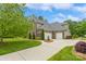 Brick house featuring a three-car garage, mature landscaping, and a well-manicured lawn for enhanced curb appeal at 10012 Royal Colony Dr, Waxhaw, NC 28173