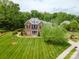 Exterior elevation of the brick house featuring a manicured lawn, mature trees, and landscaping adding to its charm at 10012 Royal Colony Dr, Waxhaw, NC 28173