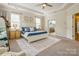 Spacious primary bedroom showcasing a tray ceiling and ensuite bathroom entrance at 10012 Royal Colony Dr, Waxhaw, NC 28173
