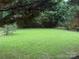 Large backyard surrounded by mature trees and natural landscaping at 1012 Kings Mountain Ln, Gastonia, NC 28054