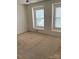 Bedroom with neutral walls, carpet flooring, and two windows that provide ample natural light at 1012 Kings Mountain Ln, Gastonia, NC 28054