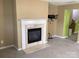 Living room showcasing a fireplace, carpet flooring, neutral walls and mounted TV stand at 1012 Kings Mountain Ln, Gastonia, NC 28054