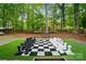 Backyard features a full-size chess board for unique entertainment amid lush greenery at 10319 Remembrance Trl, Huntersville, NC 28078