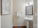 Half bathroom with pedestal sink and decorative mirror at 10319 Remembrance Trl, Huntersville, NC 28078