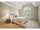 Bright bedroom featuring a large arched window, neutral walls, and plush carpeting at 10319 Remembrance Trl, Huntersville, NC 28078