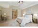 Neutral toned bedroom with vaulted ceiling, white bedding, and a small desk with seating at 10319 Remembrance Trl, Huntersville, NC 28078