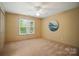 Empty bedroom with a large window, neutral colored walls and soft carpet at 10319 Remembrance Trl, Huntersville, NC 28078