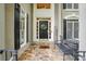 Inviting front porch with stone flooring, bench, and decorated front door at 10319 Remembrance Trl, Huntersville, NC 28078