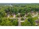 An aerial view of a home with lush trees in a serene neighborhood, showcasing well-maintained lawns and nearby amenities at 1033 Marguerite Dr, Lowell, NC 28098