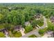 An aerial view of a home in a serene, wooded neighborhood with well-maintained lawns and mature trees at 1033 Marguerite Dr, Lowell, NC 28098