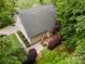 An aerial view displays the home with a spacious wooden deck, manicured landscaping, and a well-maintained yard surrounded by lush trees at 1033 Marguerite Dr, Lowell, NC 28098