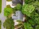 Aerial view showcasing a well-maintained home, driveway, and landscaped yard nestled among mature trees in a quiet neighborhood at 1033 Marguerite Dr, Lowell, NC 28098