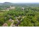 An aerial view of a home in a tranquil neighborhood surrounded by mature trees, showing well-kept lawns and community amenities at 1033 Marguerite Dr, Lowell, NC 28098