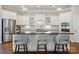 Bright kitchen features white cabinetry, stainless steel appliances, and a large center island with bar seating at 1038 Gardenia St, Fort Mill, SC 29708