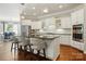 Bright kitchen features white cabinetry, stainless steel appliances, and a large center island with bar seating at 1038 Gardenia St, Fort Mill, SC 29708