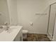 Featuring a sink, mirror, toilet and shower with dark vinyl flooring and light walls at 106 Calderdale Ln, Charlotte, NC 28262