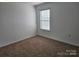 This bedroom offers natural light from a window, carpet flooring, and ample space at 106 Calderdale Ln, Charlotte, NC 28262