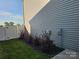 Exterior view of the home featuring vinyl siding, landscaped flower beds, and a white fence at 106 Calderdale Ln, Charlotte, NC 28262