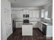 Modern kitchen with white cabinets, granite countertops, stainless steel appliances, and an island at 106 Calderdale Ln, Charlotte, NC 28262