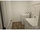Functional laundry room equipped with a washer, dryer, and overhead shelving for storage at 106 Calderdale Ln, Charlotte, NC 28262