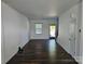 Bright living room with dark wood floors, white walls, and natural light filtering through the window at 106 Calderdale Ln, Charlotte, NC 28262