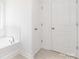 Bathroom featuring a soaking tub with tile surround and white doors at 111 Stonewater Dr # 25, Red Cross, NC 28129