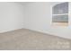 A bright bedroom featuring neutral carpet, white walls, and a window with blinds at 111 Stonewater Dr # 25, Red Cross, NC 28129