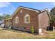 Close up exterior view with brick, wooden shuttered windows, and landscaping at 124 Hunters Creek Dr, Mooresville, NC 28115