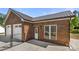 Brick garage with a white door, metal roof, and black chainlink fence at 124 Hunters Creek Dr, Mooresville, NC 28115