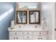 Bathroom featuring double sinks, framed mirrors, and an abundance of cabinet storage at 12628 Waterfall Pl, Charlotte, NC 28278