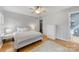 Comfortable bedroom with hardwood floors, plush rug, and ceiling fan with light fixture at 12628 Waterfall Pl, Charlotte, NC 28278